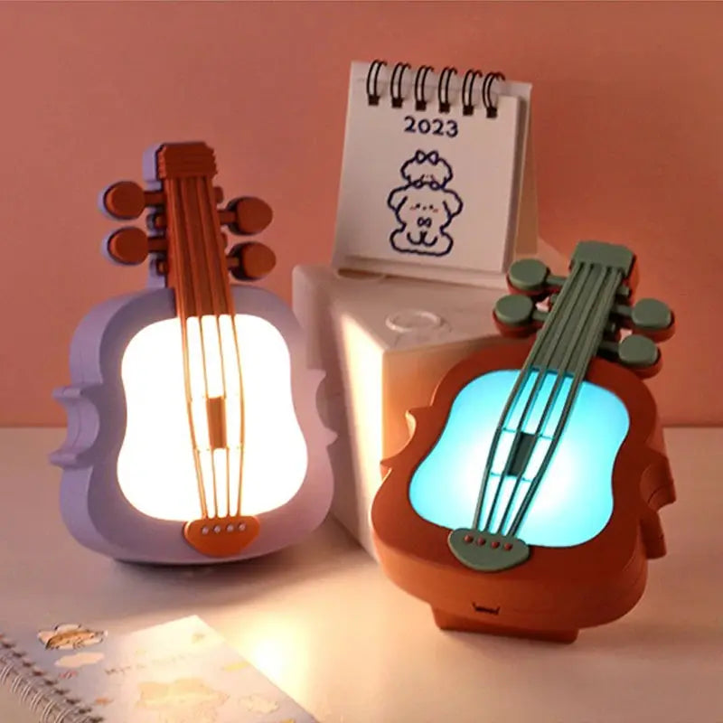 Two guitar-shaped LED night lights, purple and orange frames with white and blue glow, mini desk lamps