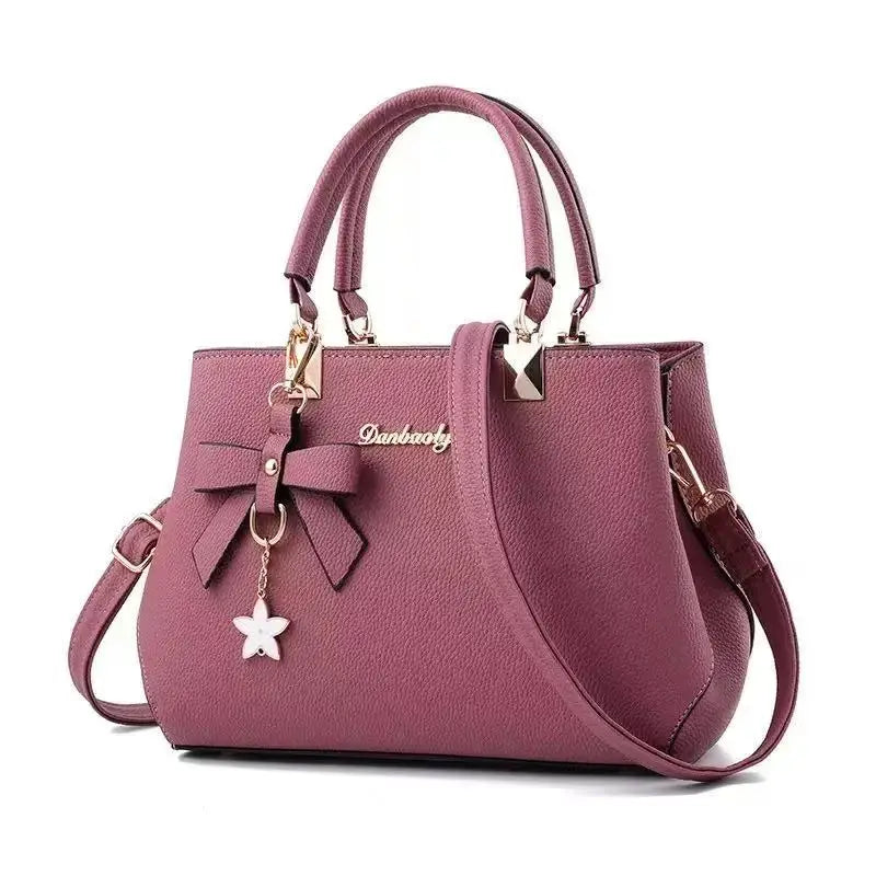 Bow handbag by Simples Market; pink pebbled faux leather with double top handles and shoulder strap