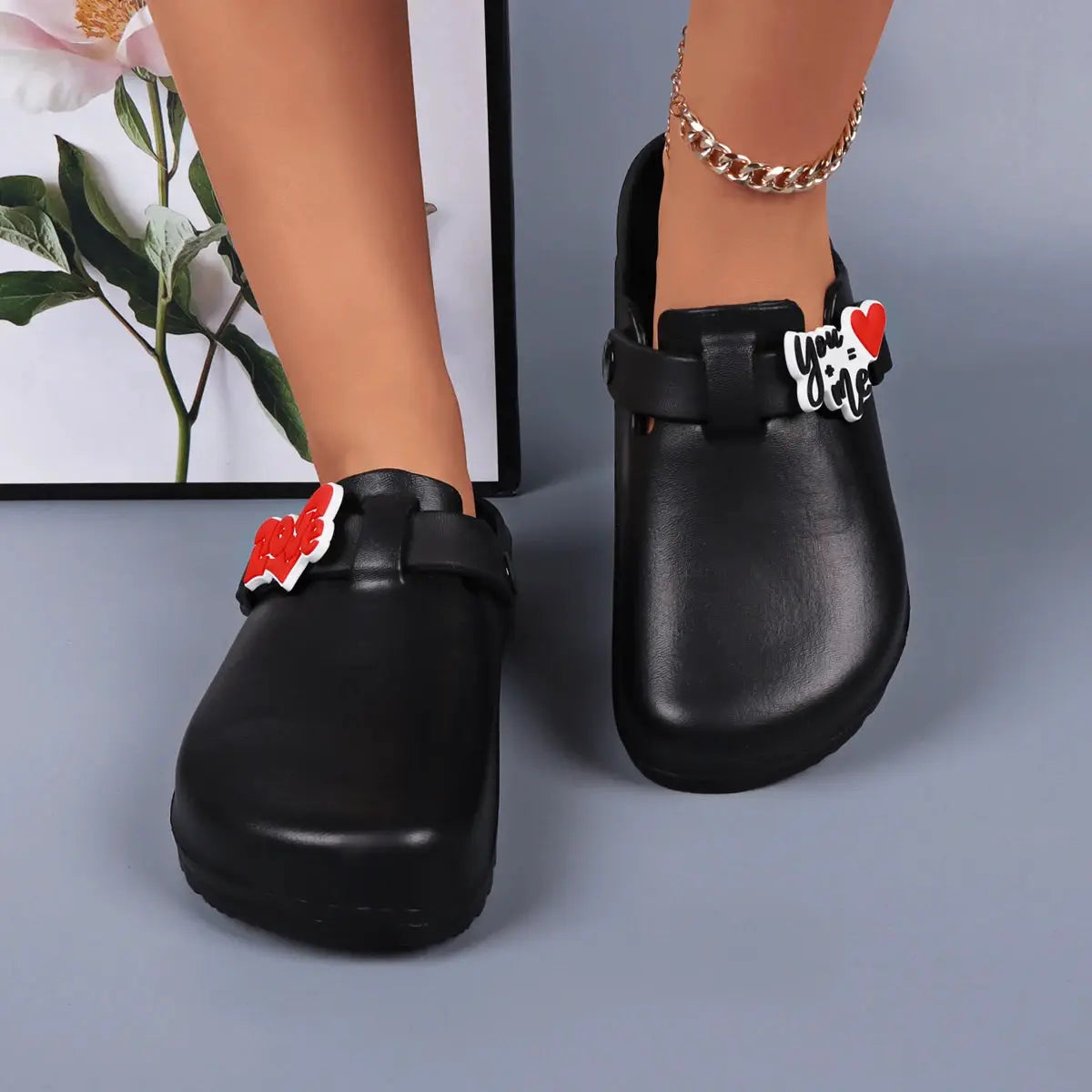 Black EVA slides for women with heart charm decorations, indoor/outdoor waterproof sandals.