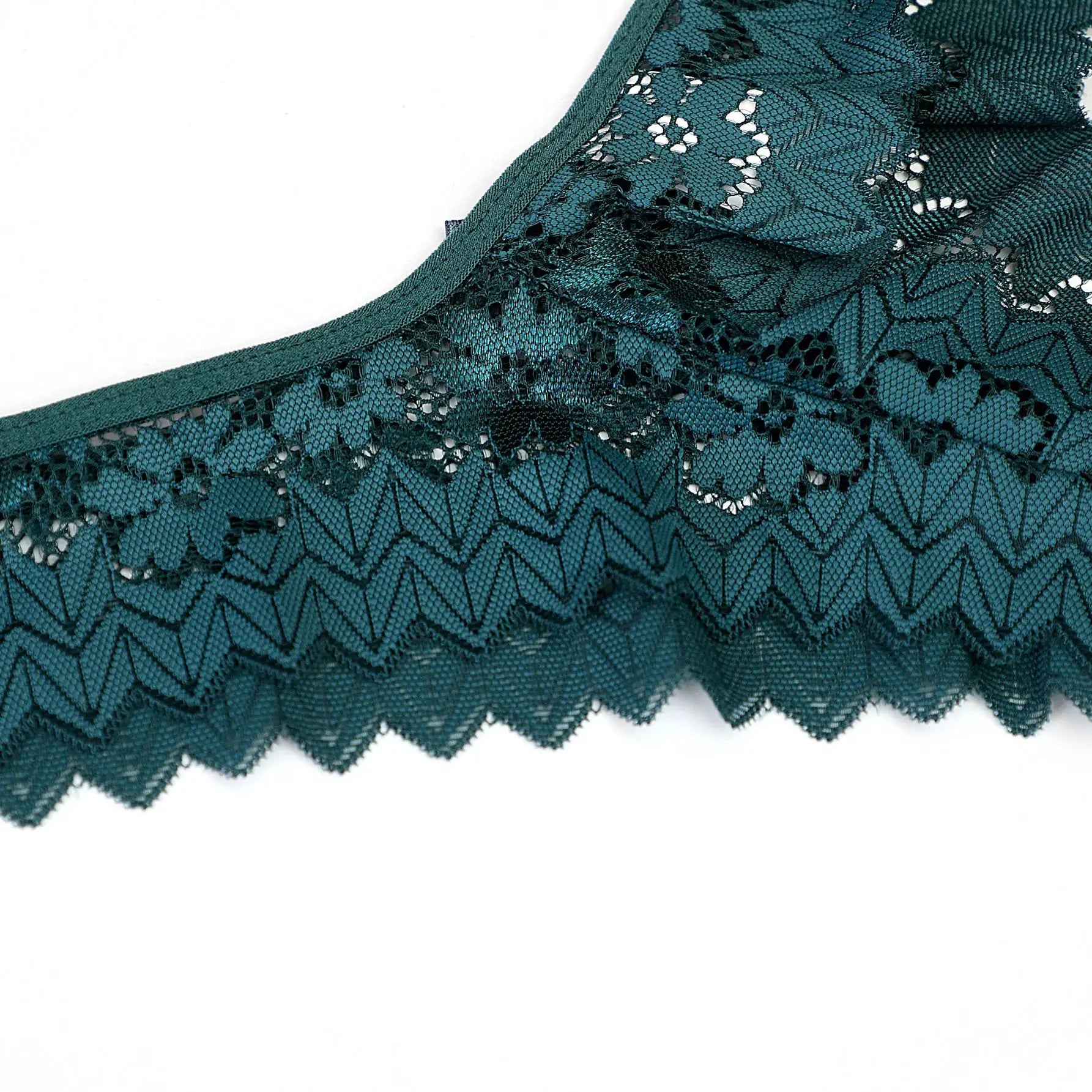 Women's teal lace thong underwear fabric close-up, showcasing intricate lace pattern