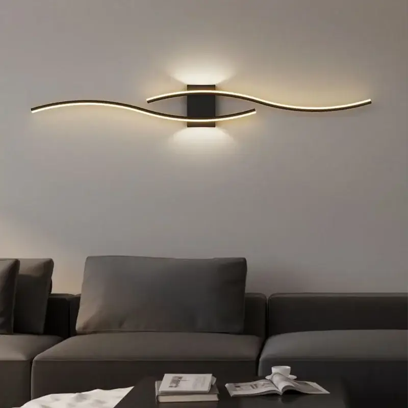 Moder LED wall lamp by Simples Market; black square mount with two curved LED strips, warm glow above a gray sofa.