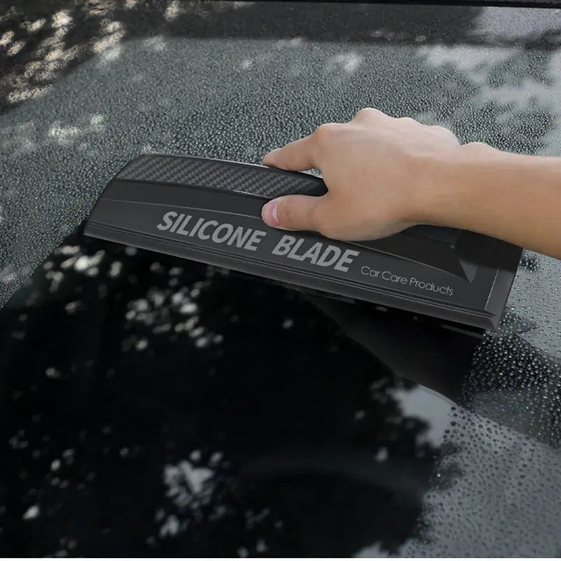 Simples Market silicone blade car squeegee with carbon-fiber pattern used on a wet windshield