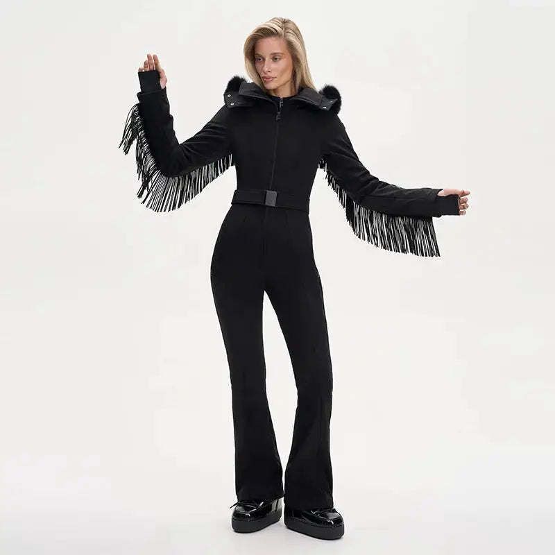 Women’s black one-piece ski suit with faux-fur hood, fringe tassel sleeves, and a high-waist belt