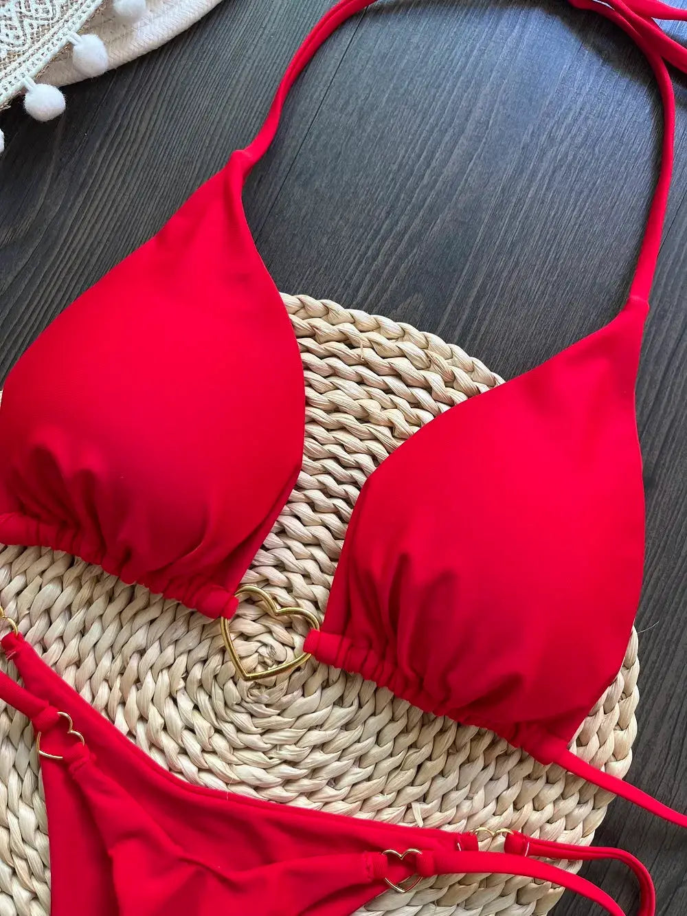 Red halter bikini set, two-piece with triangle top and thong bottoms, gold ring accents.