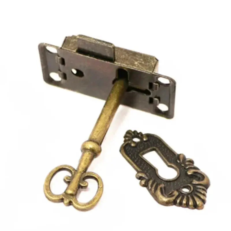 Antique brass cabinet door lock set, three-piece with ornate key and decorative escutcheon plate.
