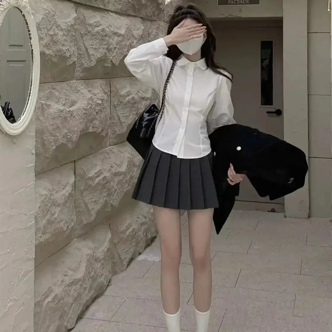 Simples Market white women's button-down shirt with long sleeves, paired with a gray pleated mini skirt
