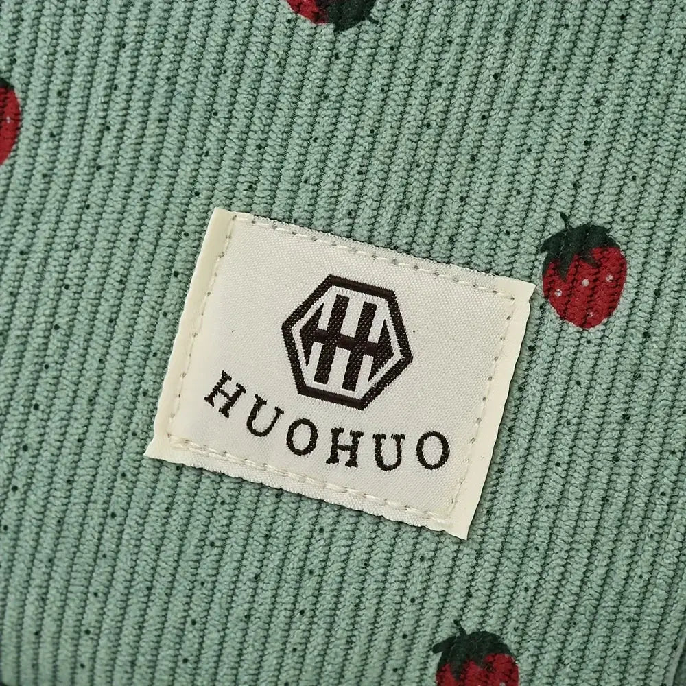 Strawberry travel bag on corduroy fabric with red berry pattern; white brand tag reads KHUOHUO.