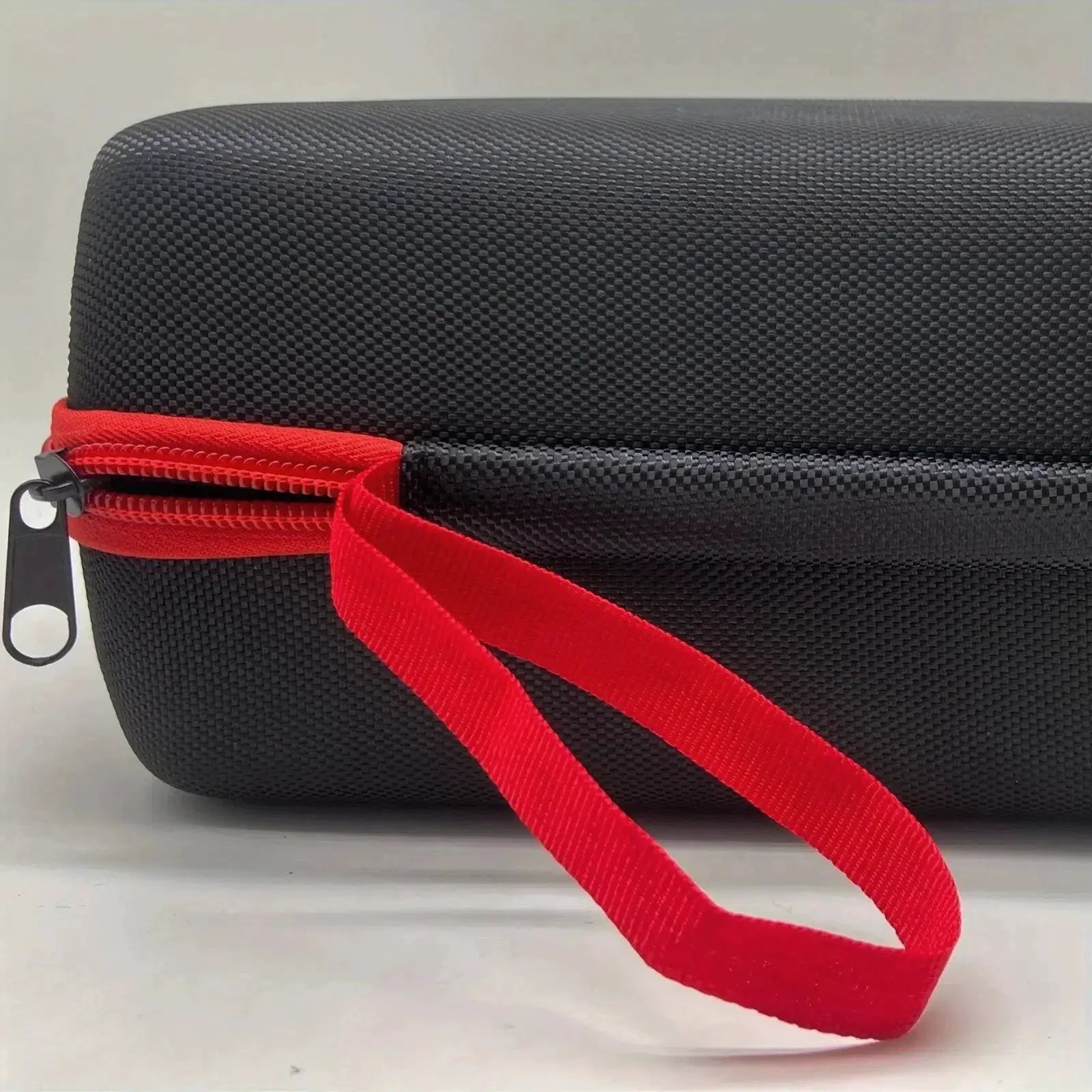 Black EVA tool organizer case with red carrying strap and metal zipper.