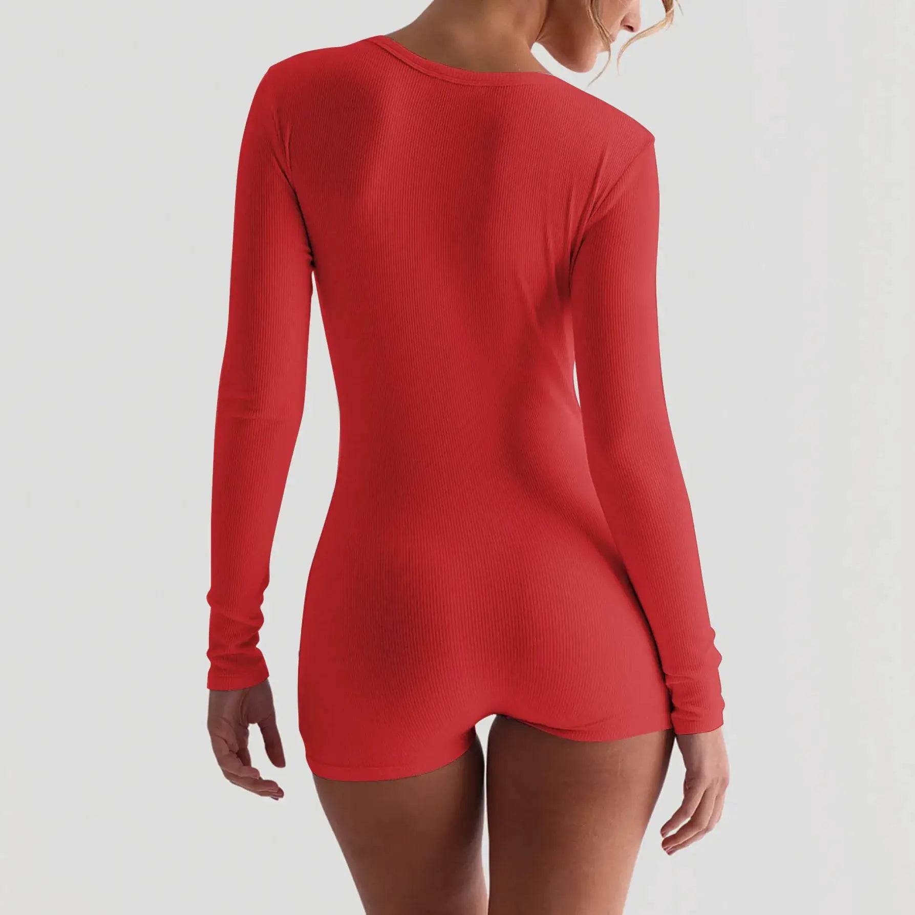 Red ribbed long-sleeve playsuit seen from the back; form-fitting bodycon romper.