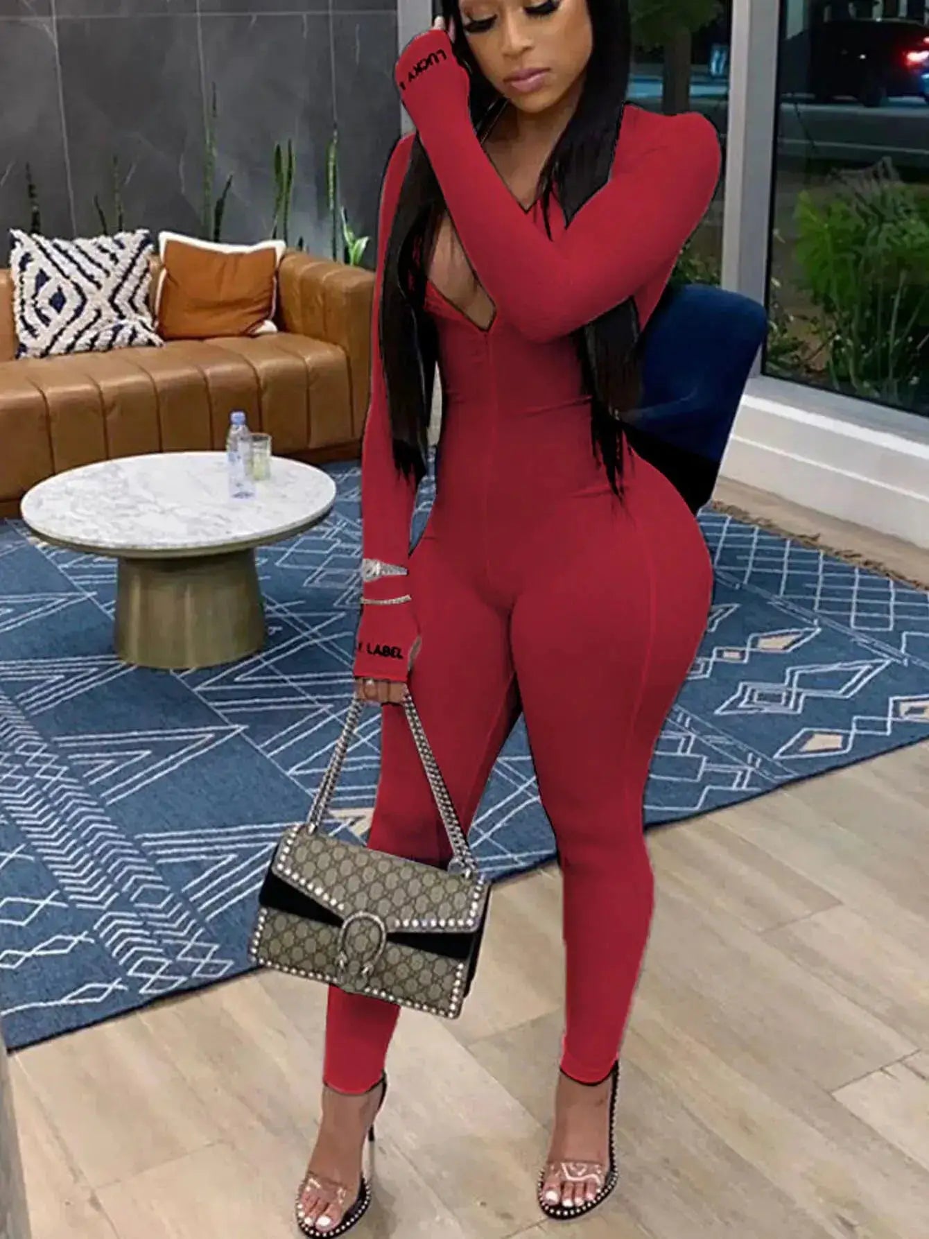 Red long-sleeve knit bodycon jumpsuit by Simples Market with a deep V neckline and fitted silhouette