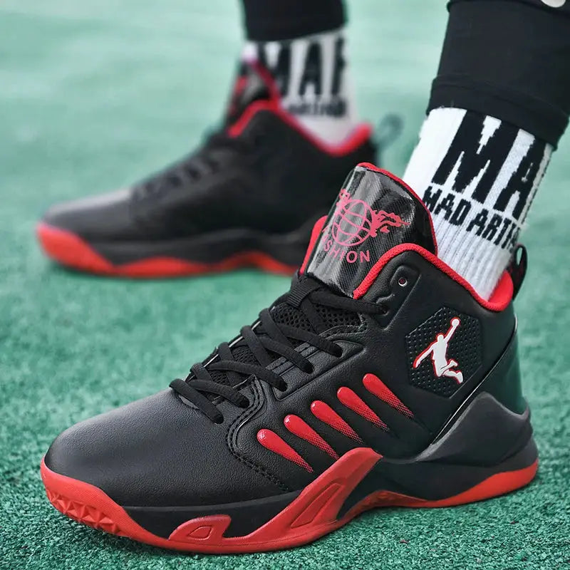 Men's black sneakers with red accents and white side logo on green turf.