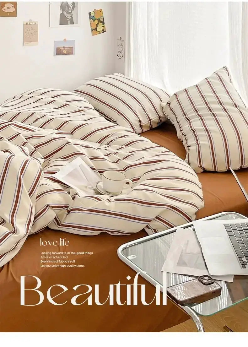 Duvet cover and four-piece washed cotton bedding set in red and blue stripes by Simples Market on the bed