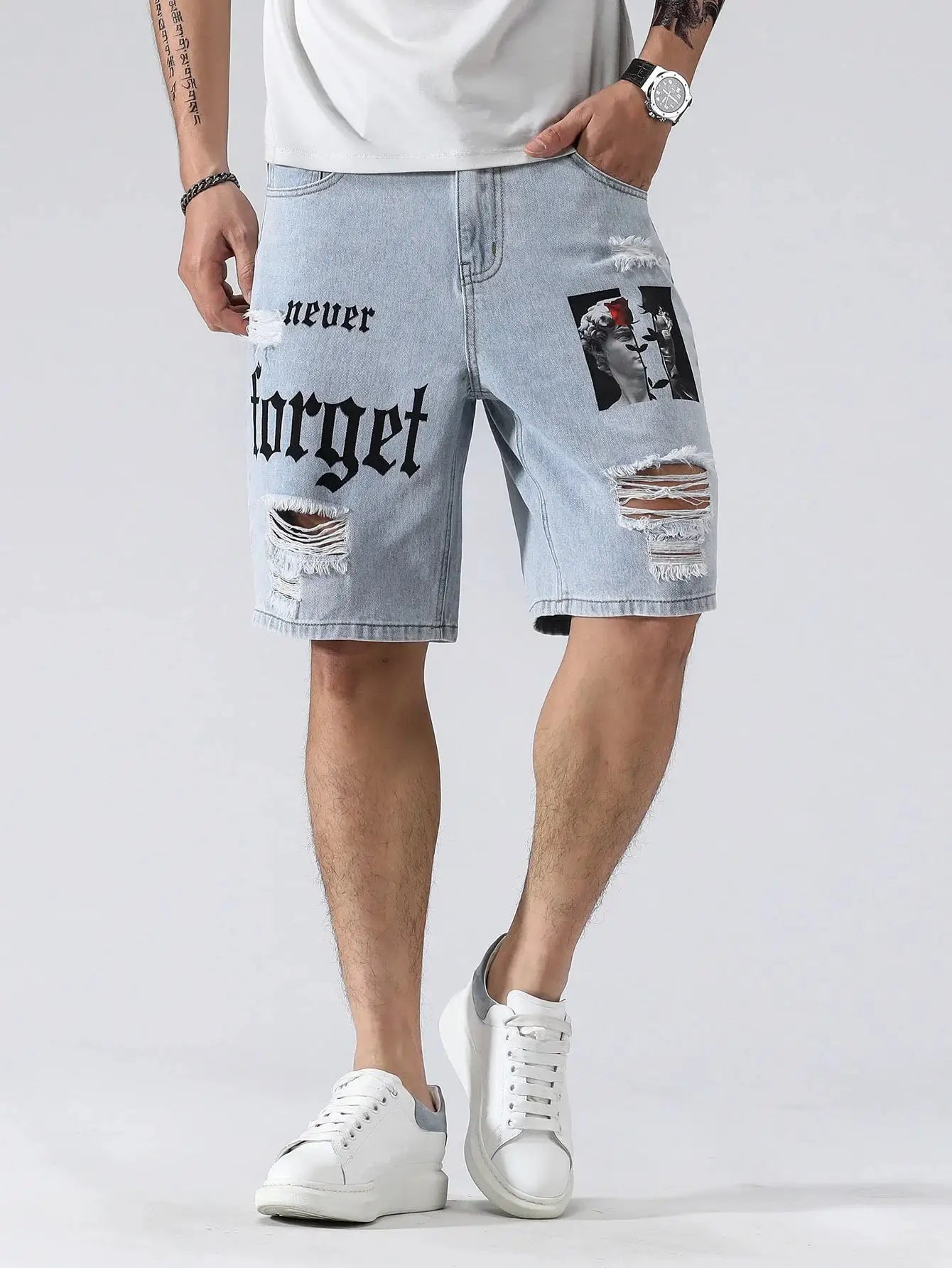 Men's light denim shorts with ripped knees and graphic patches, knee-length casual streetwear.