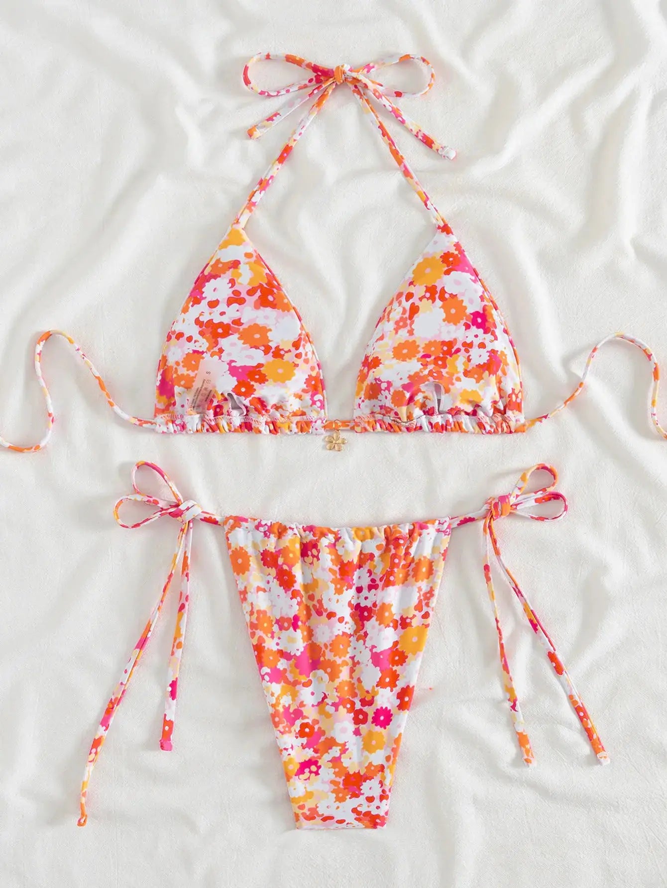 Two-piece floral bikini set with triangle top and adjustable tie sides in orange-pink print