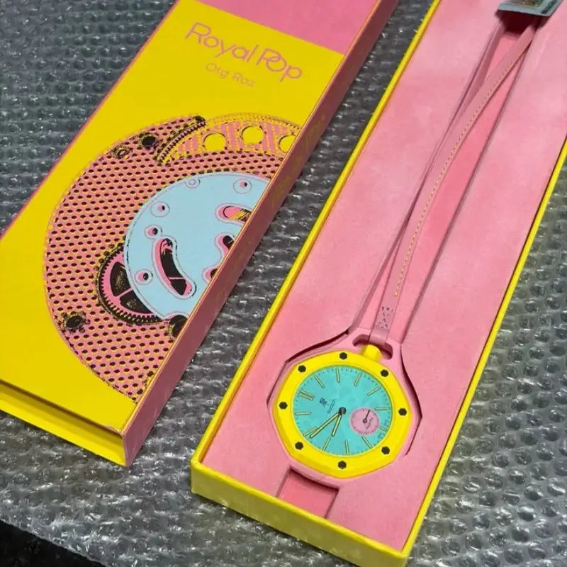 AP Swatch joint watch with pink strap, yellow bezel and turquoise dial in pink-and-yellow packaging