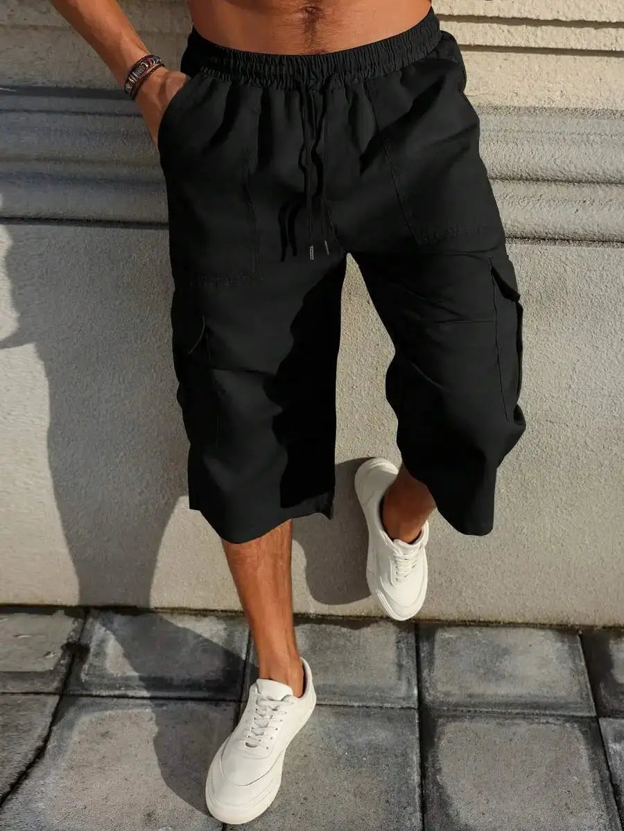 Manfinity Homme black cargo shorts with drawstring and multiple pockets; baggy capri length.