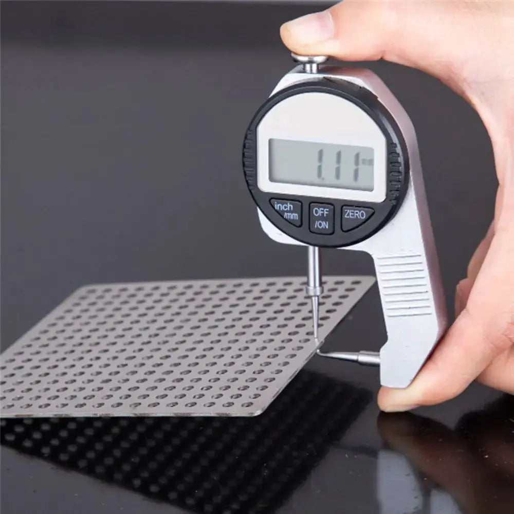 Stainless steel square floor drain cover with perforated holes, measured with a digital caliper