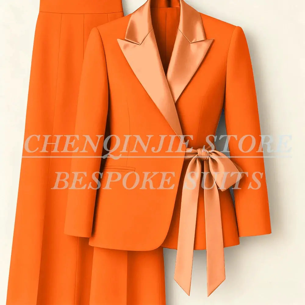 Orange 2-piece women's blazer and pants suit with peach satin peak lapels and waist-tie belt