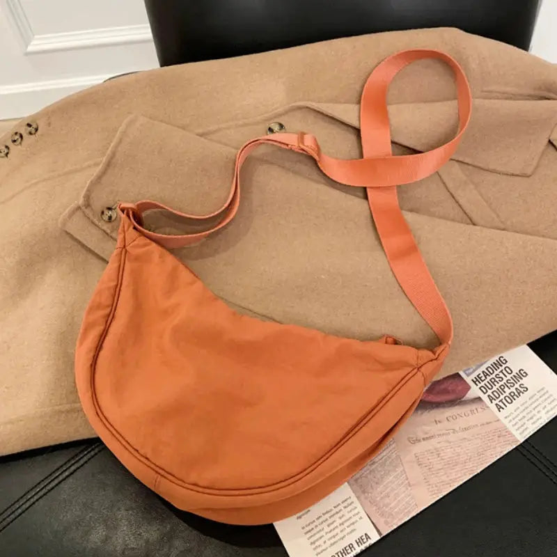 Casual nylon hobo crossbody bag in orange with a long adjustable strap and large capacity