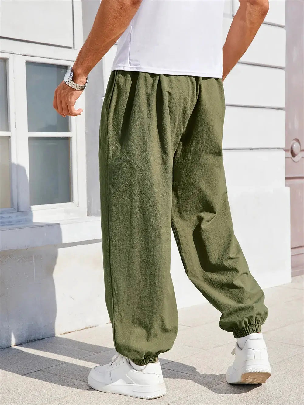 Men's loose-fit harem pants in olive green cotton-linen, with elastic cuffs for casual jogger style.