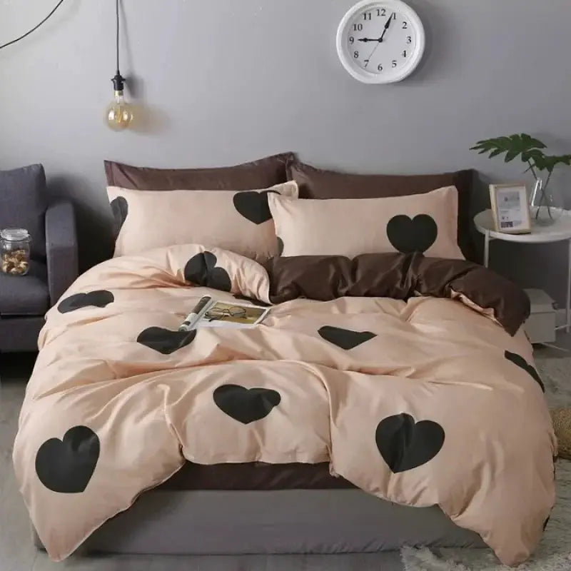 Peach cotton four-piece bedding set with black heart pattern, including quilt cover and matching pillowcases
