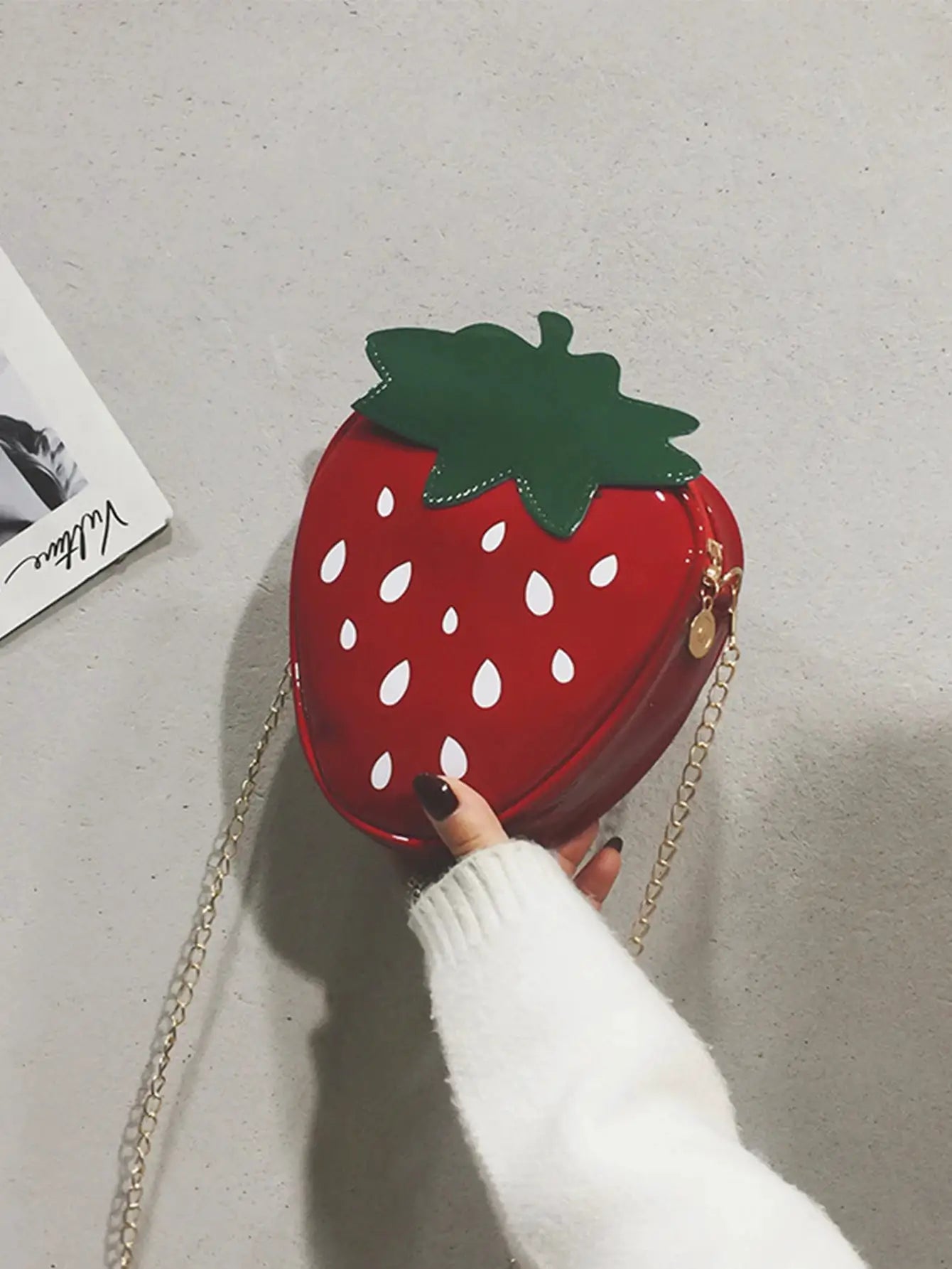 Strawberry-shaped crossbody bag; red with green leaf top and gold chain strap by Simples Market.