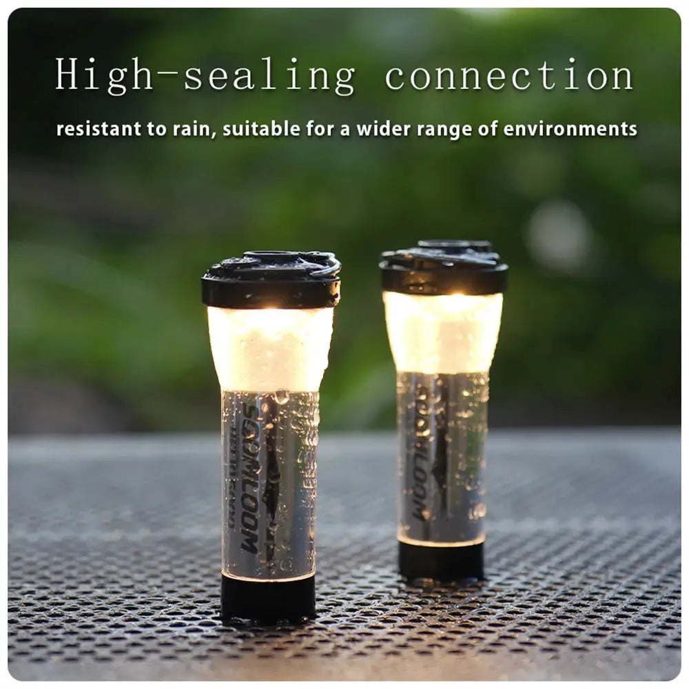Two Soomloom Helio 5000 camping lanterns with clear bodies and black caps, IPX4 waterproof LED lamps.