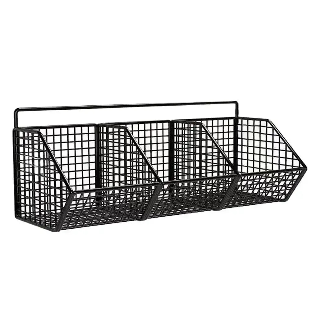 Simples Market wall-mounted black metal wire storage basket with three compartments for spices, garlic, and onions.