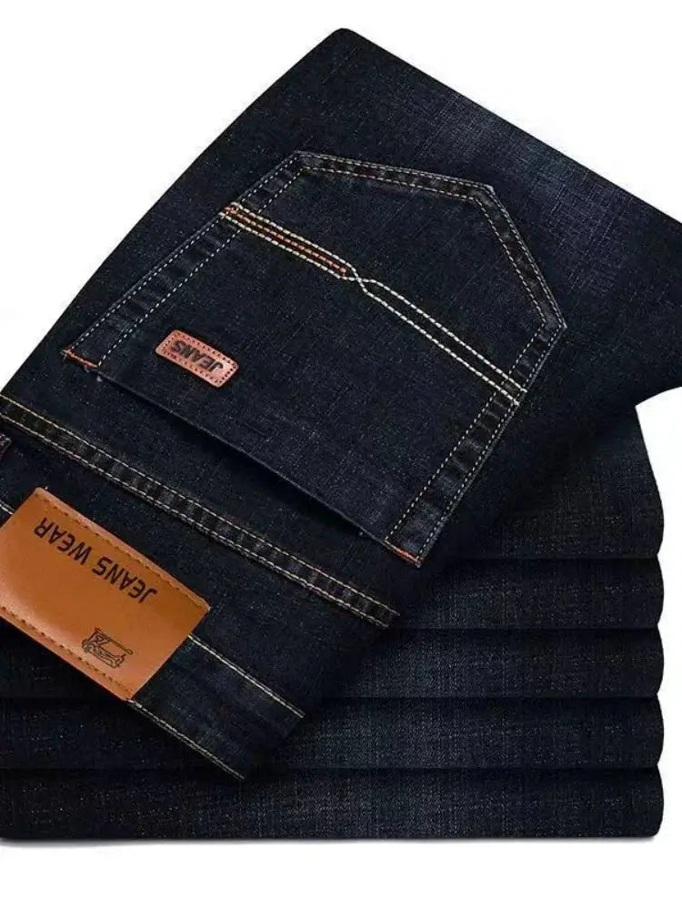 Men's dark blue denim jeans, casual straight-leg style, stacked with back pocket and tan leather patch