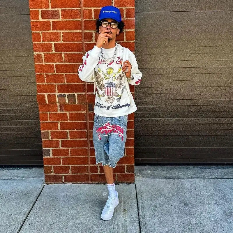 Y2K graffiti denim jorts; distressed blue shorts with pink graffiti print, unisex baggy fit for streetwear style