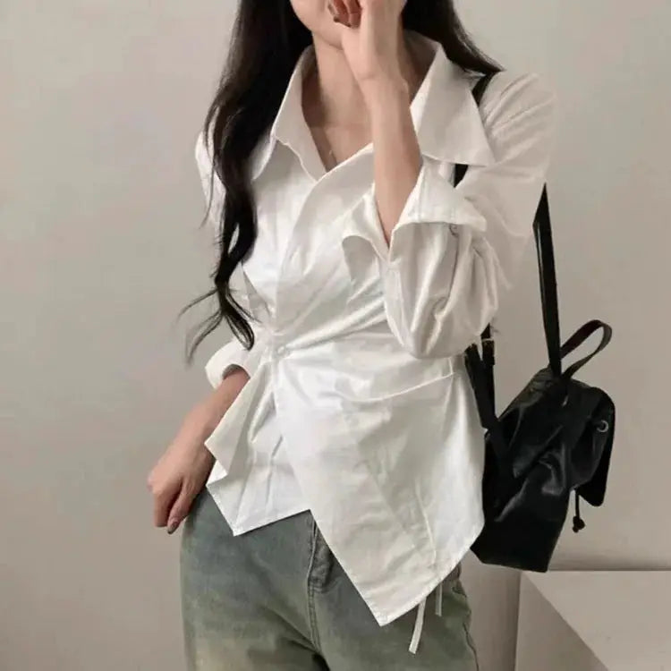 White wrap blouse with belt by Simples Market, long sleeves, paired with jeans and a black backpack