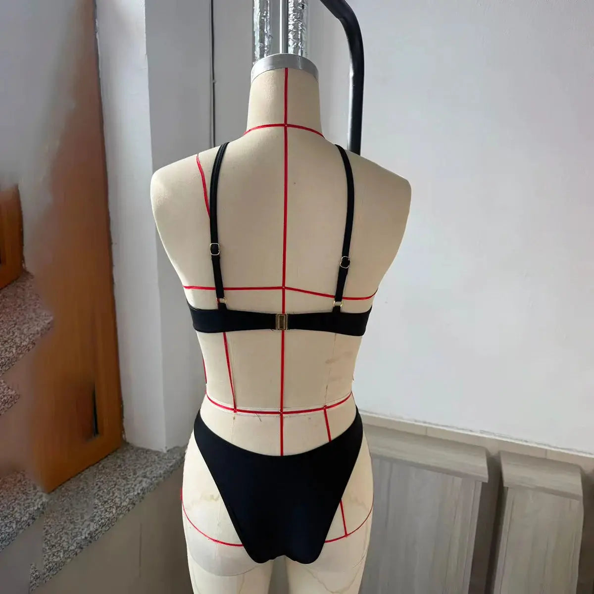 3-piece black bikini set displayed on mannequin with adjustable straps and matching bottom.