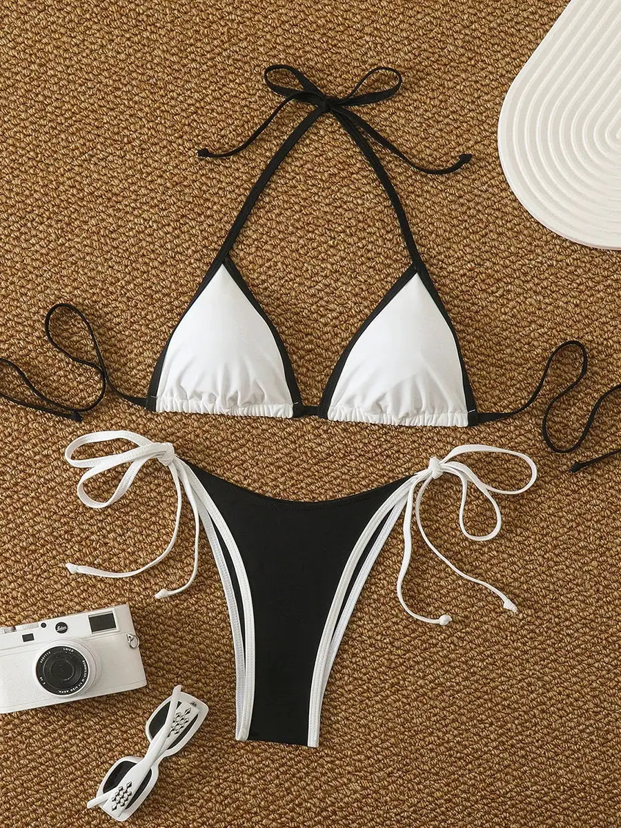 Simples Market two-piece bikini set, white triangle-top with black trim and black side-tie bottom on a woven mat