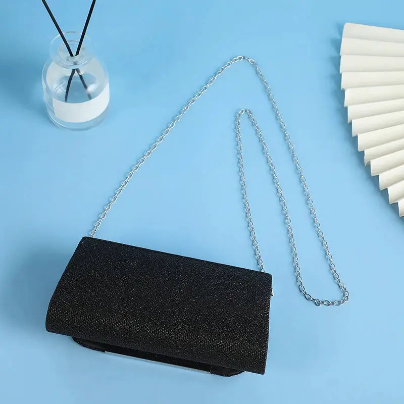 Sequined black clutch bag with silver chain strap for evening wear by Simples Market