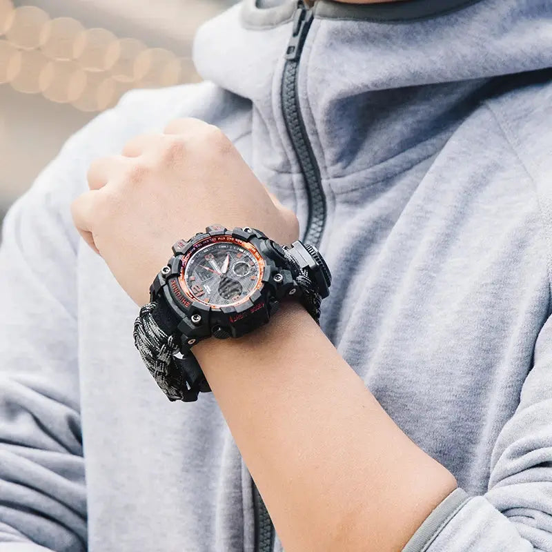 SHIYUNM men's military sports watch with black case, orange bezel, and paracord strap.