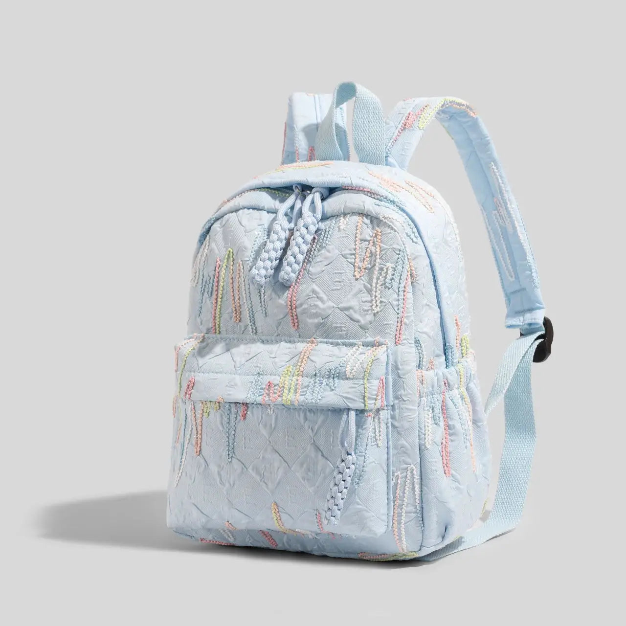 Simples Market women's mini backpack in light blue quilted fabric with pastel embroidery, zipper closure, adjustable straps