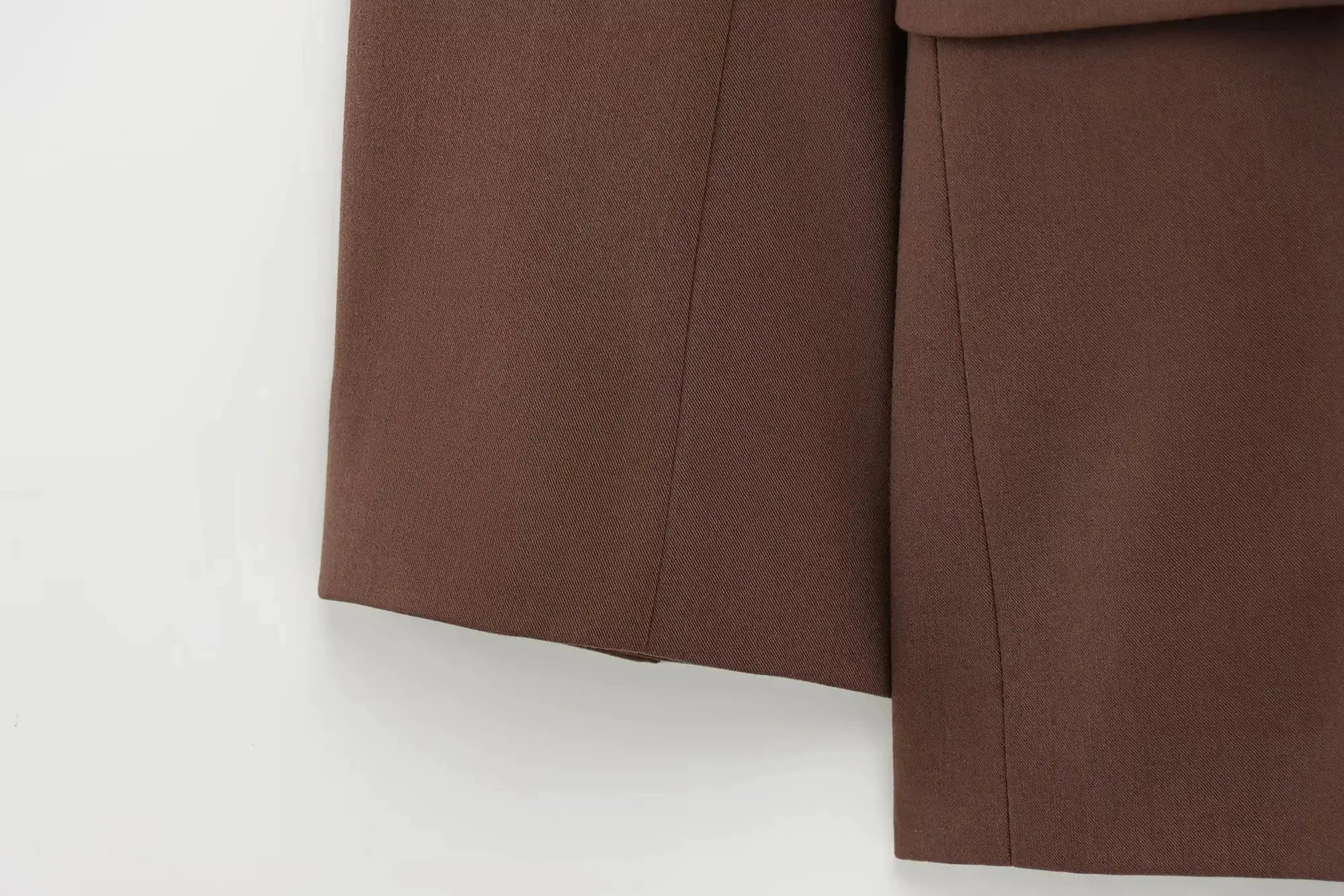 KONDALA brown solid blazer and matching pants suit fabric close-up showing seam details.