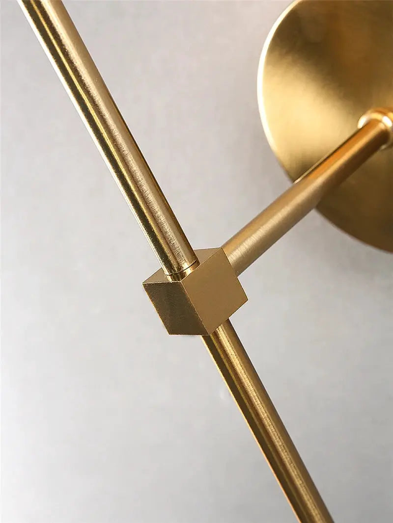 Modern brass wall lamp with gold metal rod and square clamp, wall mount visible