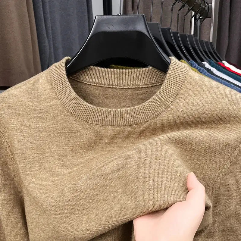 Men's beige knitted crew-neck sweater on hanger; long sleeves, casual style.