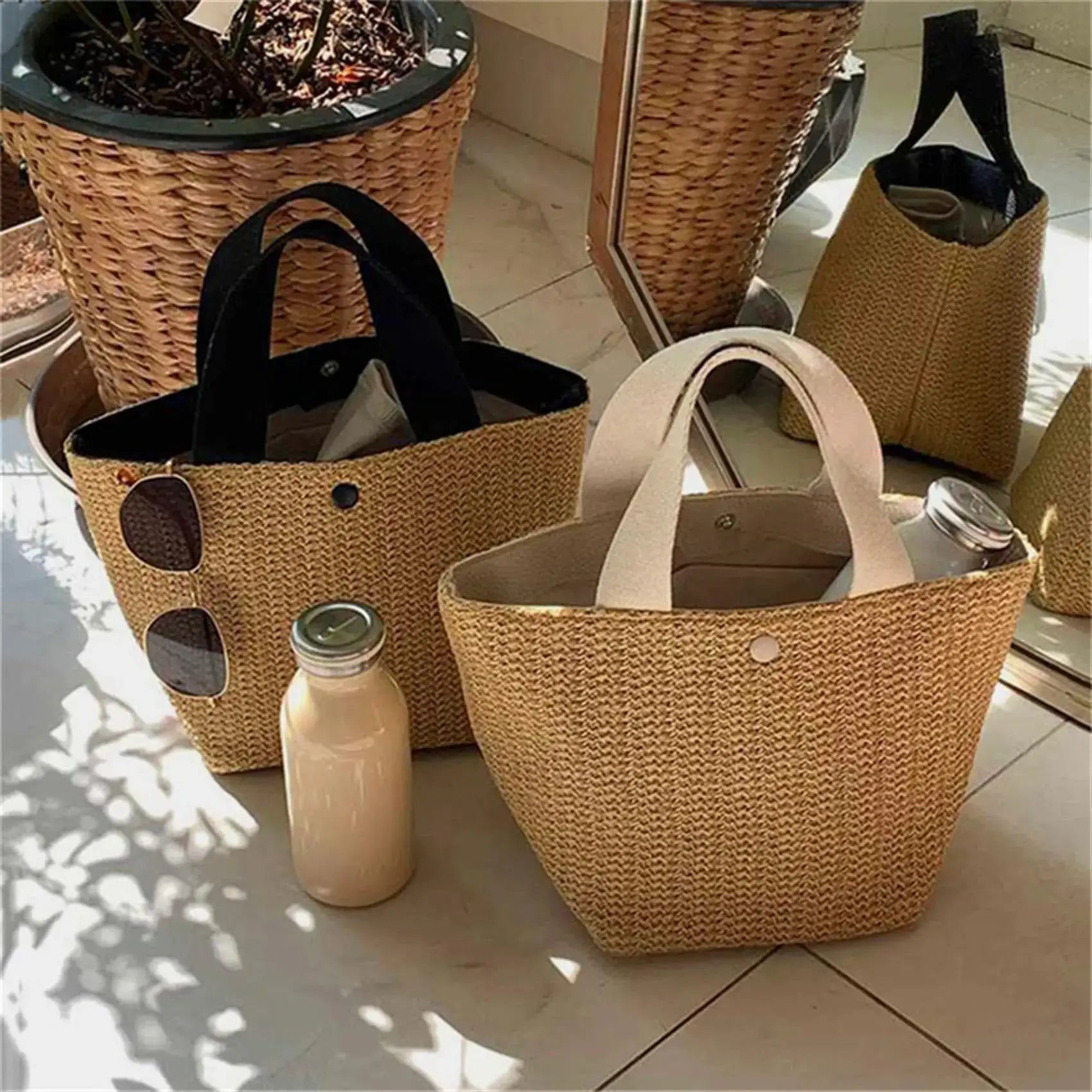 Elegant straw woven tote bags by Simples Market; set of three beige beach bags with black handles, sunglasses.