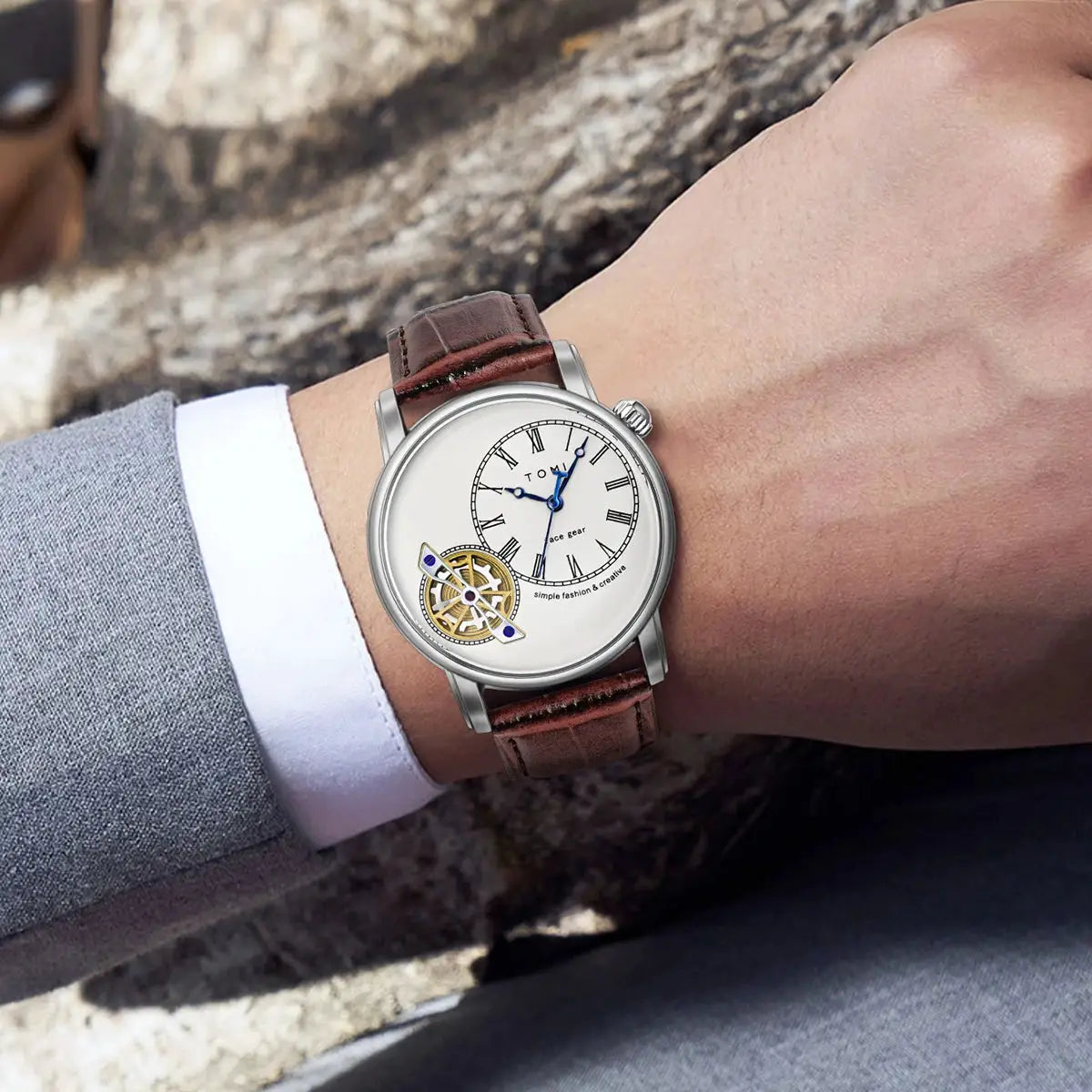 TOMI men's quartz watch with brown leather strap and silver case, blue hands on white dial.