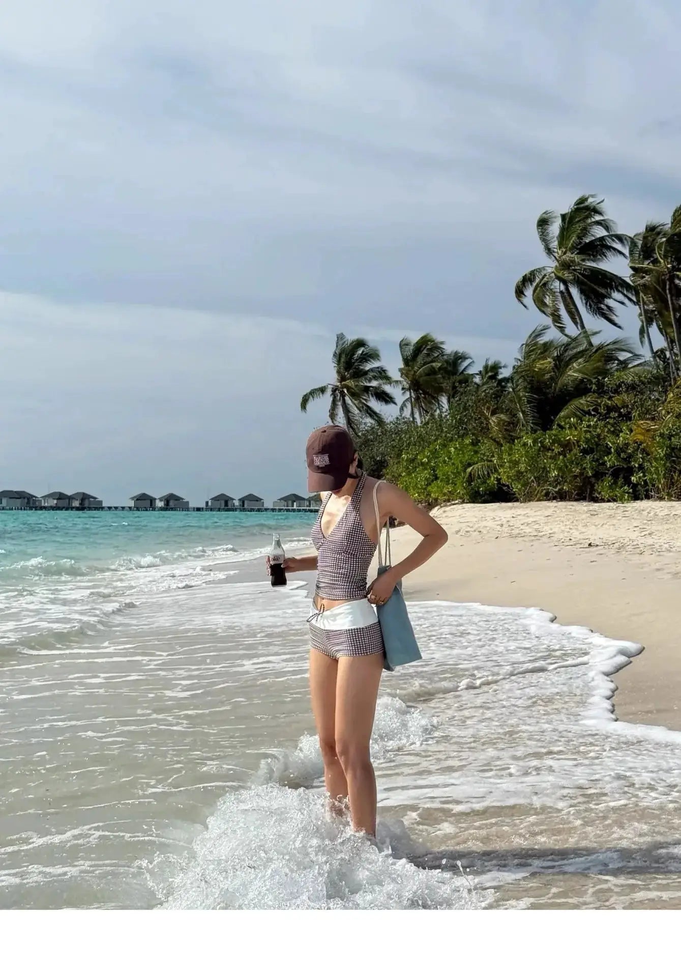 Bikini set on model at the beach; black-and-white checkered high-waisted two-piece with deep-V push-up top