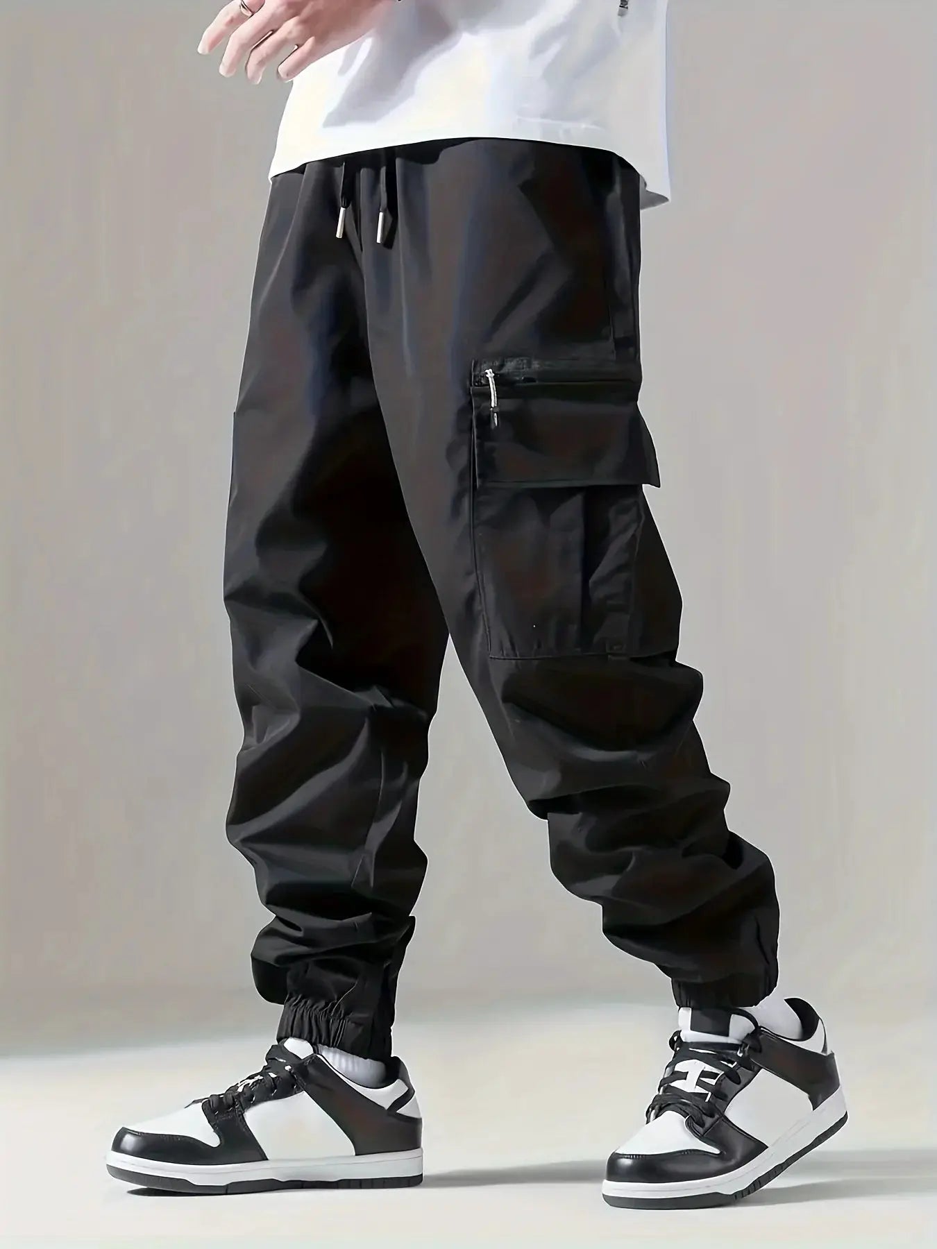 Men's black cargo pants with zippered side pocket, drawstring waist, and elastic cuffs
