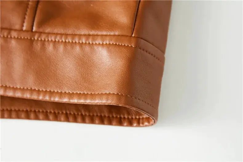 Leather jacket sleeve cuff in brown with stitched seams.