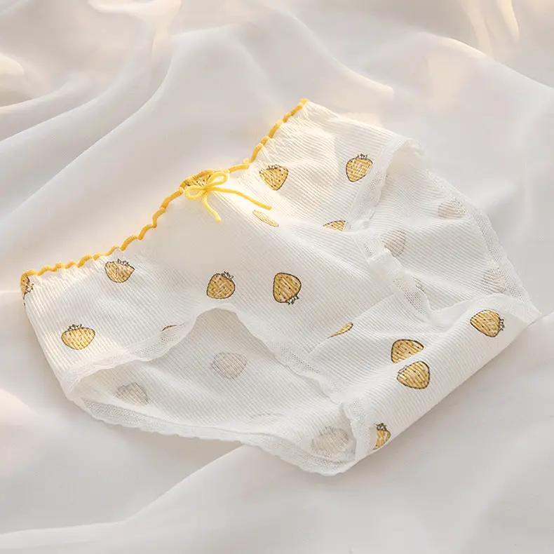 Women's white cotton underwear briefs with yellow peach prints, mid-waist with lace trim.