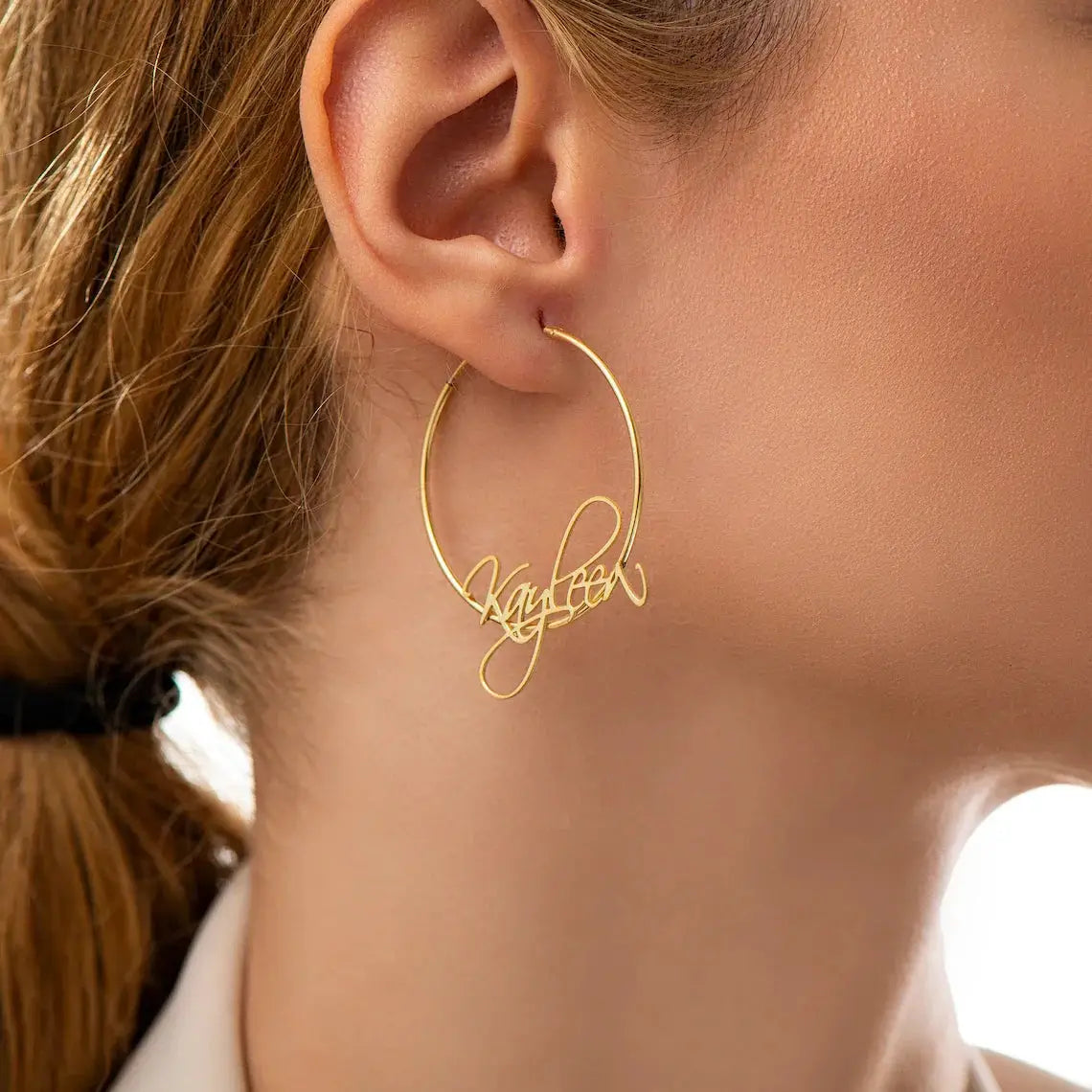 Gold-tone stainless steel 70mm hoop earring with a custom script nameplate