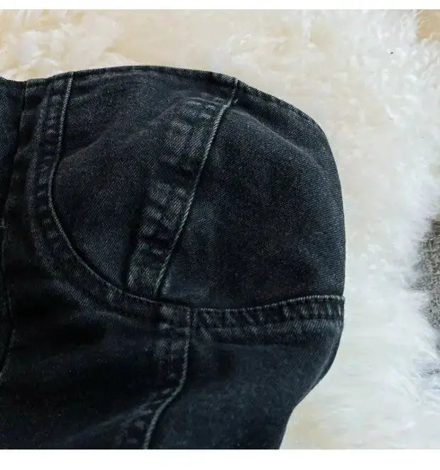 Denim romper fabric close-up with dark wash and visible stitching