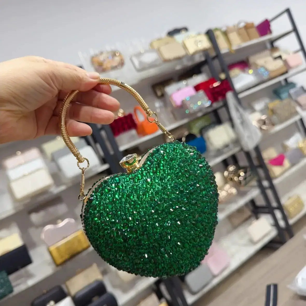 Green crystal heart-shaped clutch purse by Simples Market with gold chain