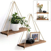 Two-tier wood hanging shelf set on hemp ropes with plant pot on top shelf and camera and framed photo on bottom.