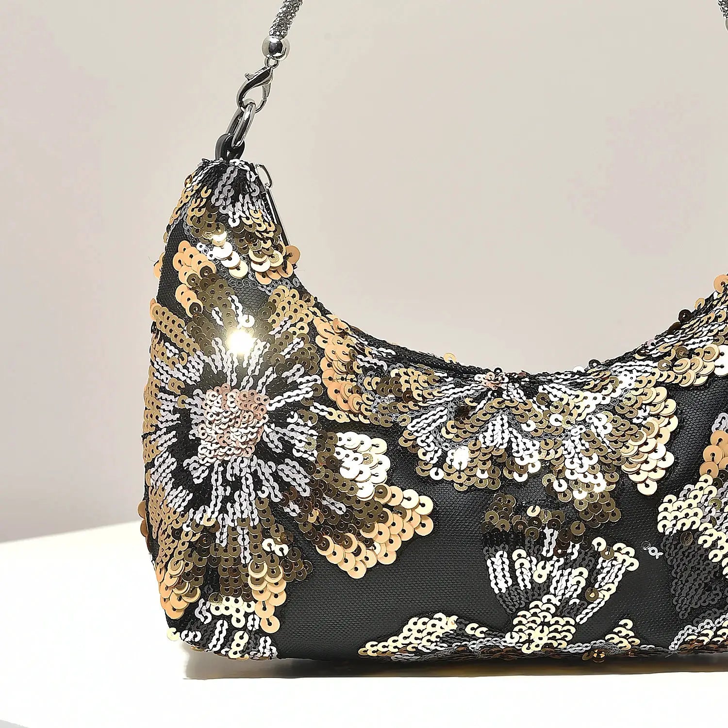 Shoulder bag with black base, gold and silver sequin floral embroidery and chain strap.